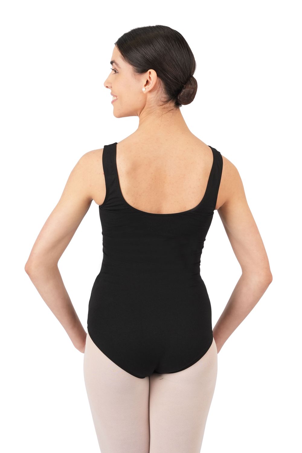 Selbstbewusst stehende Frau im ärmellosen schwarzen Trikot R3101 von Rumpf, die Hände in die Hüften gestemmt, den Blick leicht nach rechts gerichtet.